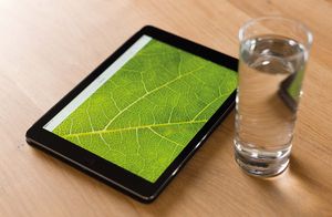 Ipad mit einem Glas Wasser