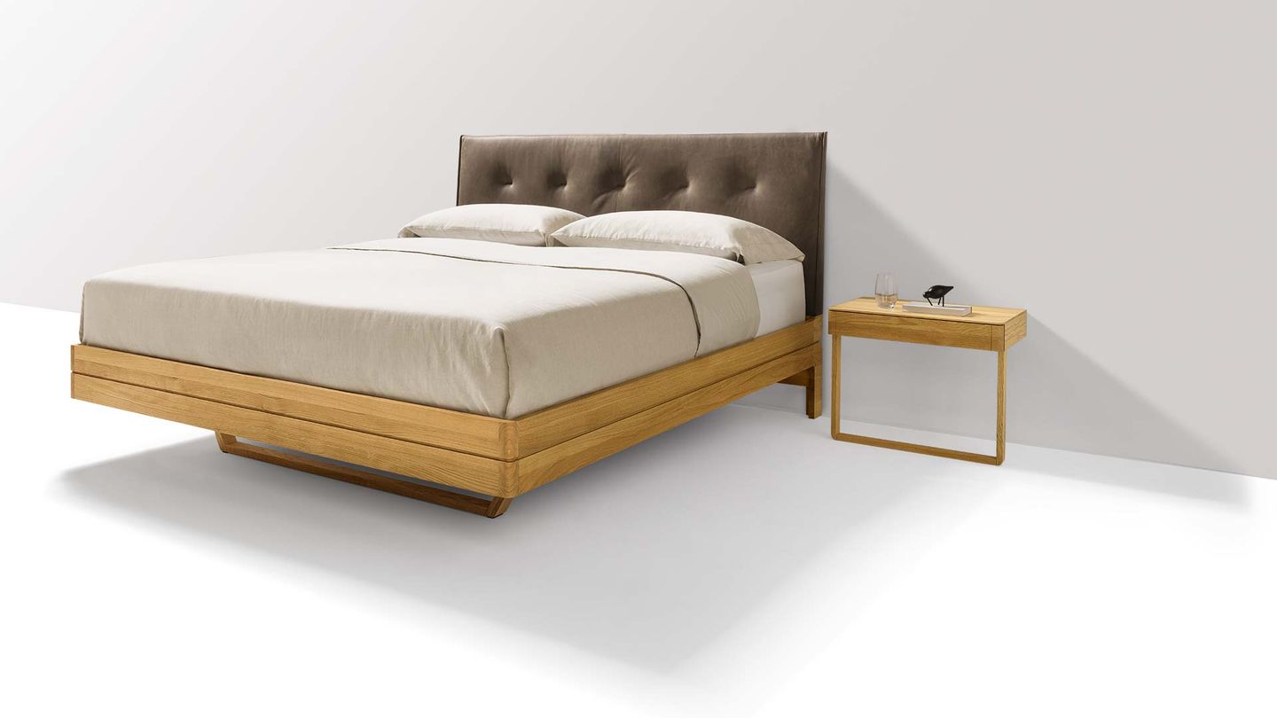 Designer bed made of wood with leather headboard Designer bed made of wood with leather headboard